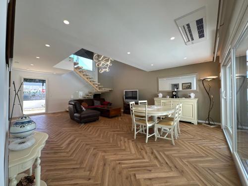 a living room with a table and chairs and a staircase at Maison bord mer près de le Lisbonne in Charneca