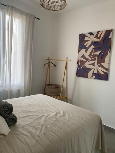 une chambre avec un lit et un tableau au mur dans l'établissement T3 avec jardin, proche plage & commodités, à Fos-sur-Mer