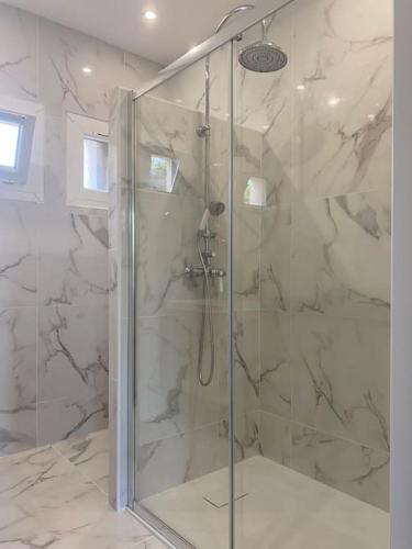 une douche avec une porte vitrée dans une salle de bain dans l'établissement T3 avec jardin, proche plage & commodités, à Fos-sur-Mer