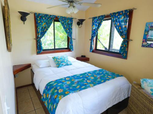 a bedroom with a bed and two windows at West Bay Lodge and Spa in West Bay