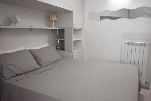 a bedroom with a white bed and a white wall at Dimora Vima in Monopoli
