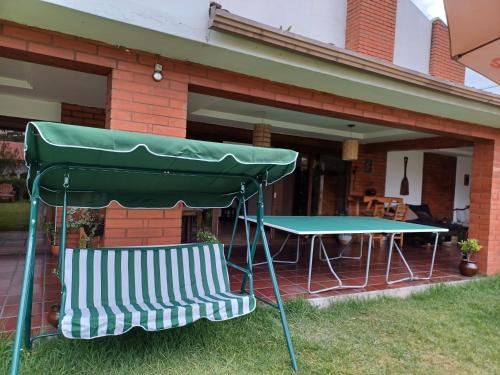a picnic table and two chairs in front of a house at Hostal Mochiliers Bed and Breakfast in Cuenca