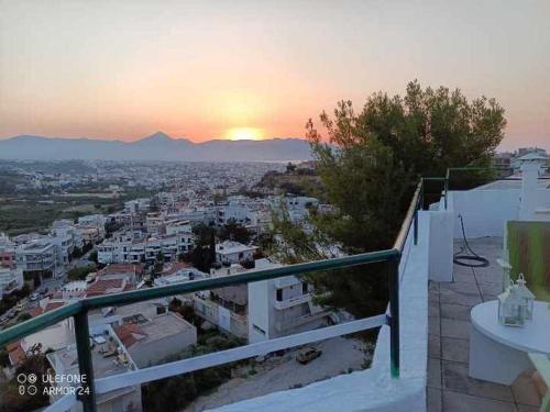 a view of a city at sunset from a balcony at Nikos Sunset Penthouse in Mastambás