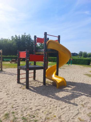 a playground with a slide in the sand at Ferienhaus Strandnah in Breskens