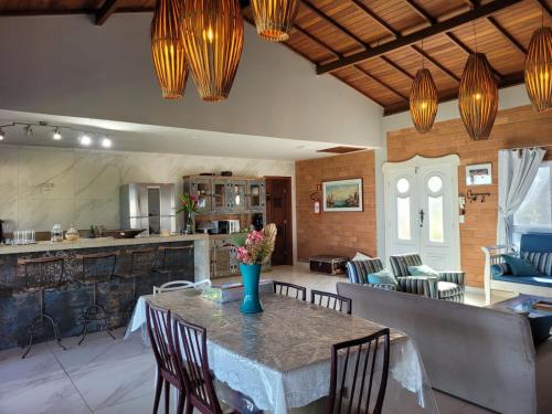 a kitchen and dining room with a table and chairs at Villa Jardim Mar in Anchieta