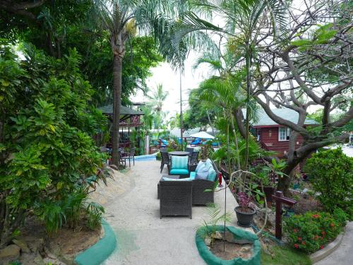 a patio with a couch and chairs in a garden at West Bay Lodge and Spa in West Bay
