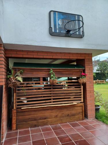 a building with a wooden wall with potted plants at Hostal Mochiliers Bed and Breakfast in Cuenca