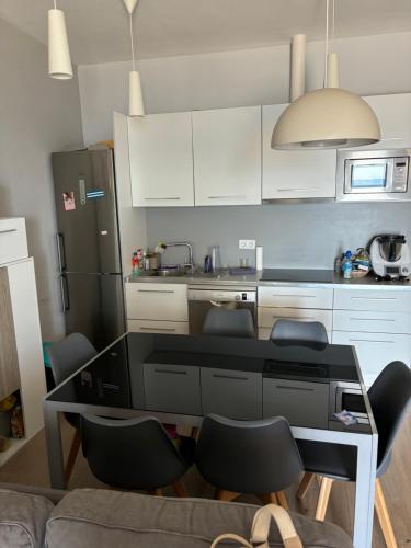 Una cocina con mesa y sillas y un refrigerador. en Apartamento 1ª línea de playa, en Almería