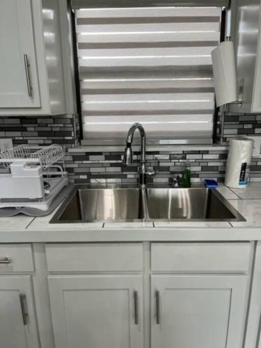 a kitchen with a stainless steel sink and white cabinets at Willow Ridge Cove in West Monroe