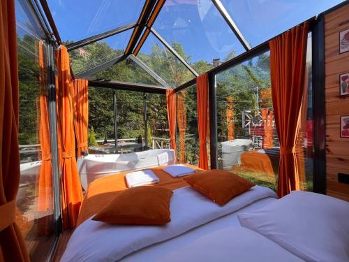 a bedroom with a bed in a glass house at Moon River Bungalow in Ayder Yaylasi