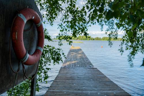 a wooden dock with a red object on the water at Holiday Village Anttoora - Anttooran Lomakylä in Pori