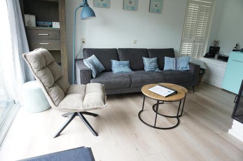 a living room with a couch and a table at Kustverhuur, Park Schoneveld, Zeester 38 in Breskens