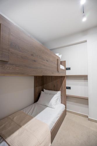 a bedroom with a bed with a wooden headboard at Sunny Sands Seaview Apartment in Archangelos