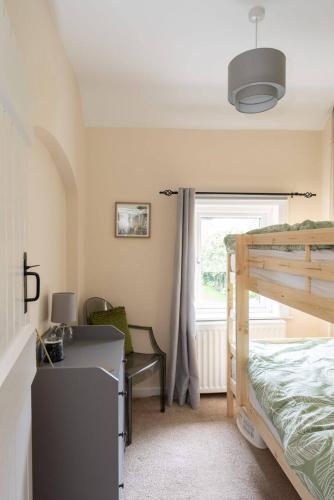 a bedroom with a bed and a desk and a window at Quaint 3 bed Cottage in central Dorking with parking in Dorking