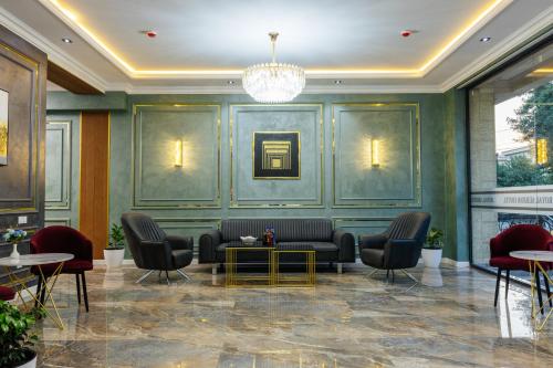 a lobby with a couch and chairs and a table at Royal Sebzor Hotel in Tashkent