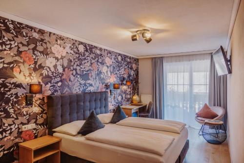 a bedroom with a bed and a floral wall at Landhotel Gschirnwirt in Eugendorf