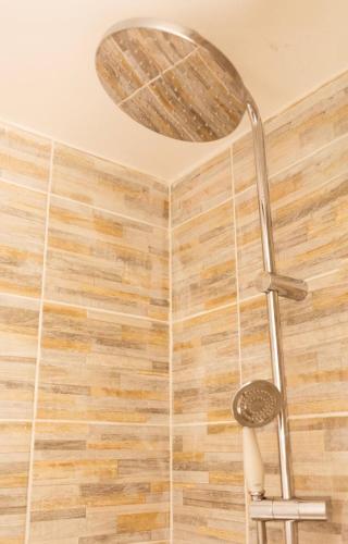 une douche avec pommeau de douche dans une salle de bain dans l'établissement Le cocon des pipots plein centre calme, à Boulogne-sur-Mer