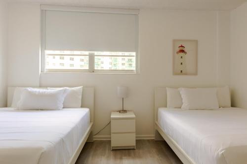 two white beds in a room with a window at PROMO Komffy Apt with 2 Queen Beds & Ocean View at Tides 7th floor in Hollywood