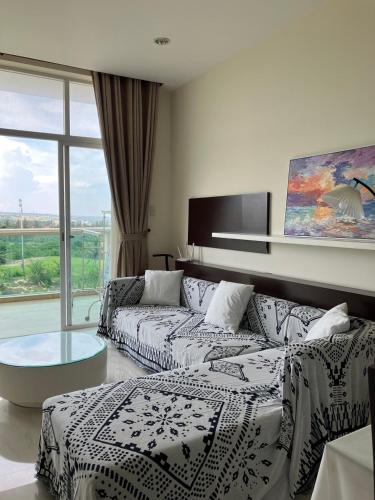 a living room with a couch and a large window at Hotel,Căn Hộ Mũi Né Sea link in Phan Thiet