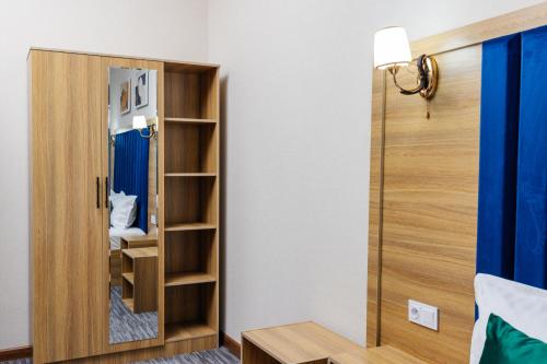 a room with a mirror and a closet at Royal Sebzor Hotel in Tashkent