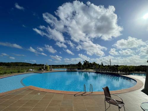 ein großes Schwimmbecken mit zwei Stühlen und einem blauen in der Unterkunft Jacuipe Country in Campos