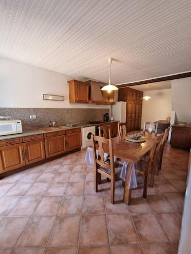 Il comprend une cuisine avec une table et des chaises en bois. dans l'établissement Charmante maison à louer, à Bastelicaccia