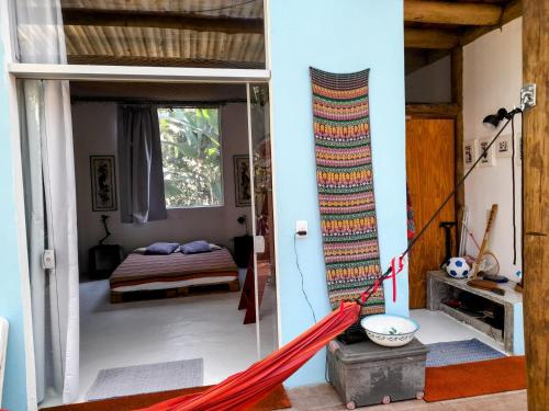 a bedroom with a bed and a hammock in a room at Quartos em sítio exuberante in Barra Grande