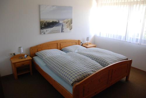 ein Schlafzimmer mit einem Holzbett mit zwei Nachttischen in der Unterkunft Haus Reiser in Alpirsbach