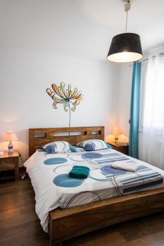 une chambre avec un grand lit avec des oreillers bleus dans l'établissement Aux coquelicots sauvages, à Pont-Saint-Martin
