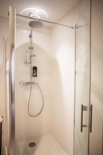 une douche avec une porte vitrée dans une salle de bain dans l'établissement Aux coquelicots sauvages, à Pont-Saint-Martin