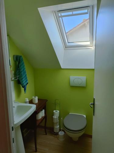 La salle de bains est pourvue d'un lavabo et de toilettes avec une lucarne. dans l'établissement Luna, à La Coquille