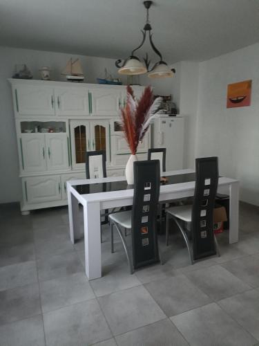 une salle à manger avec une table et des chaises blanches dans l'établissement Luna, à La Coquille
