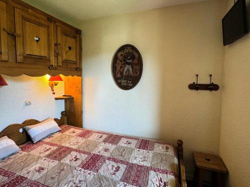 une chambre avec un lit et une horloge au mur dans l'établissement Résidence Callisto - 2 Pièces pour 5 Personnes 90, à Mâcot La Plagne