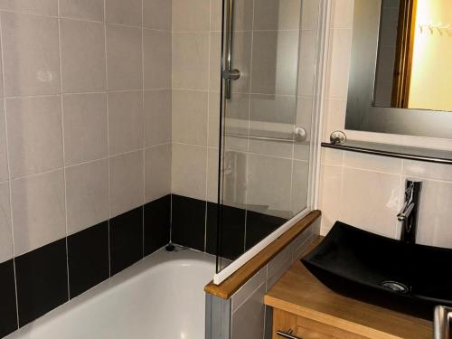 une salle de bain avec une baignoire et un lavabo dans l'établissement Résidence Callisto - 2 Pièces pour 5 Personnes 90, à Mâcot La Plagne