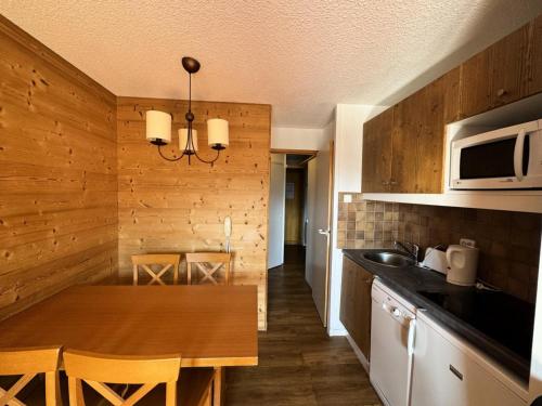 - une cuisine avec un mur en bois et une table en bois dans l'établissement Résidence Callisto - Studio pour 4 Personnes 05, à Mâcot La Plagne