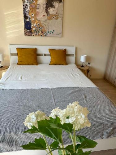 a bedroom with a bed with a vase of flowers at Emerald Buddha Apartment in Bansko