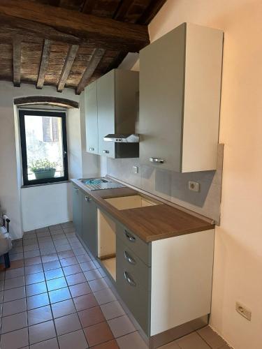 a kitchen with white cabinets and a tile floor at Rocca Casa in Roccatederighi