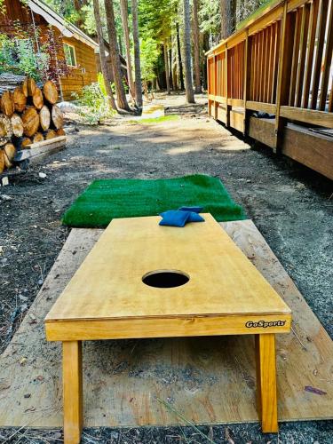 a wooden table sitting on the ground next to logs at The Aspen House in Tahoma