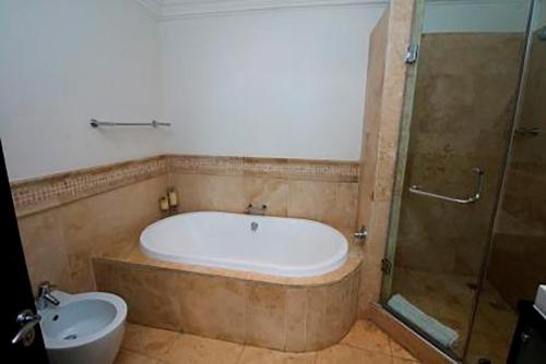 a bathroom with a tub and a shower and a toilet at 604 Ballito Manor - with generator in Ballito