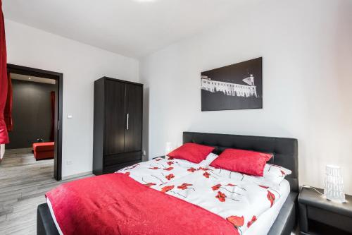 a bedroom with a large bed with red pillows at Hotel Apartments Benešova 6 in Kutná Hora
