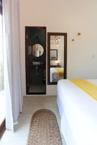 a hotel room with a bed and a mirror at Pousada Movimento in Prea