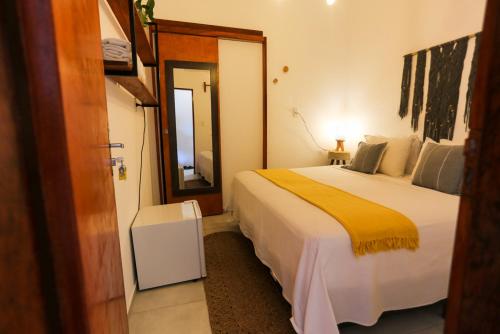 a bedroom with a large bed with a yellow blanket at Pousada Movimento in Prea