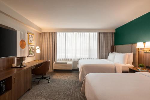 a hotel room with two beds and a desk at Holiday Inn Nashville Downtown - Stadium by IHG in Nashville