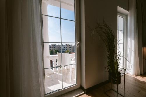 a window with a view of a balcony with white chairs at TRIBUTE Hotel in Shkodër