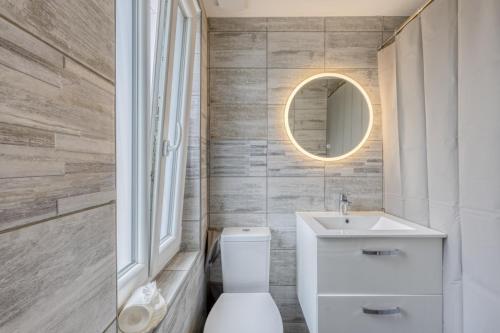 a bathroom with a toilet and a sink and a mirror at ZACH & SPA - Maison jardin à 20 min de Paris & Aéroport CDG in Livry-Gargan