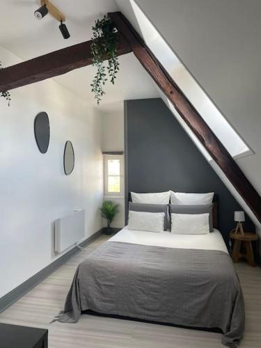 une chambre avec un grand lit dans un grenier dans l'établissement Duplex bord de l'Eure - Parking inclus - Jolie vue sur la cathédrale, à Chartres