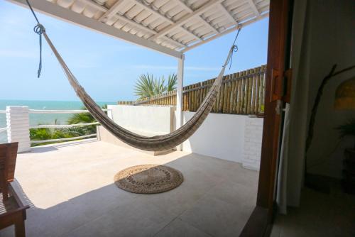 a hammock on a balcony with a view of the ocean at Pousada Movimento in Prea