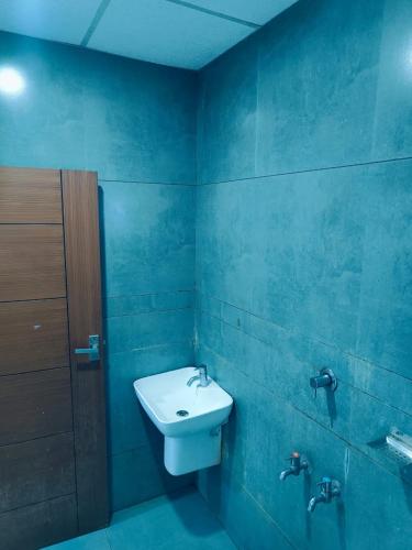 a bathroom with a sink and a blue wall at Grace Tourist Home in Ernakulam