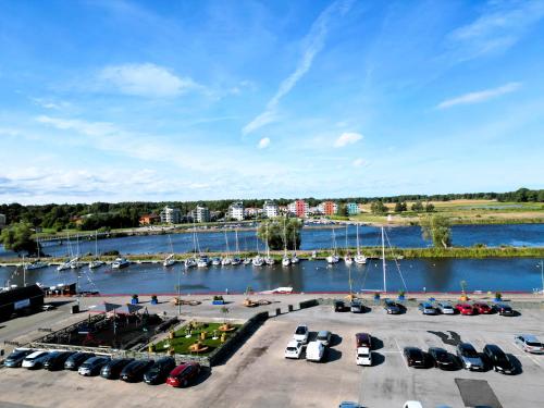 a group of cars parked in a parking lot next to a marina at Vänerport Lakefront Hotell in Mariestad