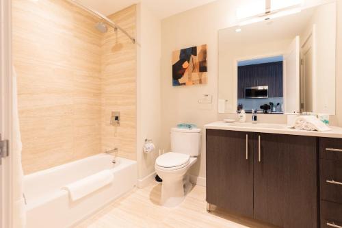 a bathroom with a toilet and a tub and a sink at Bright & Modern Apt Downtown Seaport in Boston